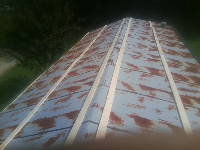 Rusted metal roof panels with new wood purlins before replacement — Storm Damage Roof Repair in Acton by Roofing Brothers